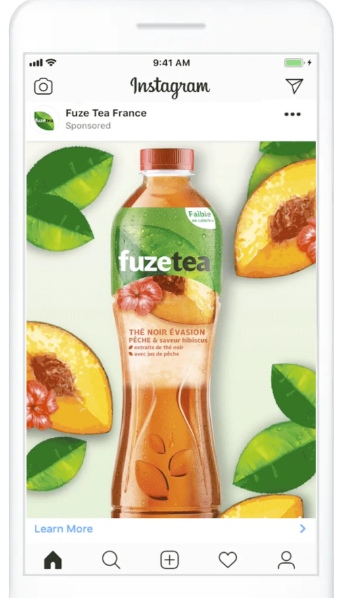 Statická reklama na Instagramu od značky Fuze Tea s lahví ledového čaje obklopenou broskvemi a zelenými listy.